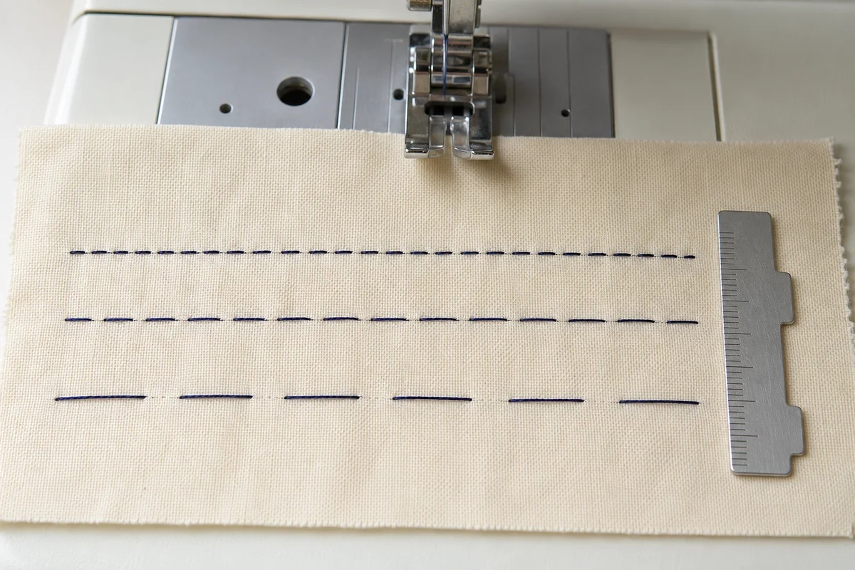 Three straight-stitch rows showing short, medium and long stitch lengths on cream cotton