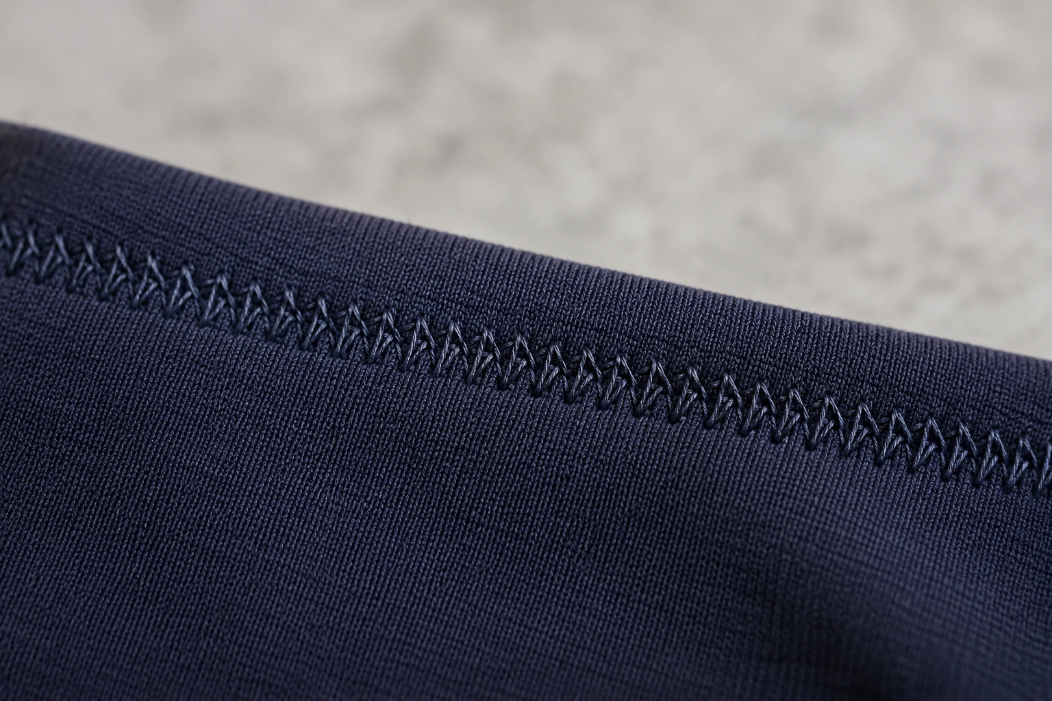 Flexible stretch stitch sewn across dark navy knit fabric